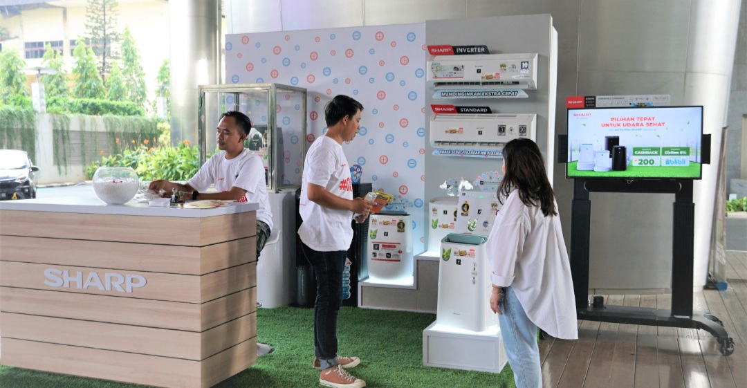 Pengunjung yang sedang bertanya mengenai produk air purifier Sharp di booth Sharp