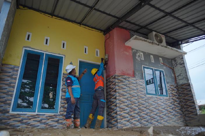 Ilustrasi petugas PLN saat melakukan perbaikan meter listrik rumah warga pasca terendam banjir.