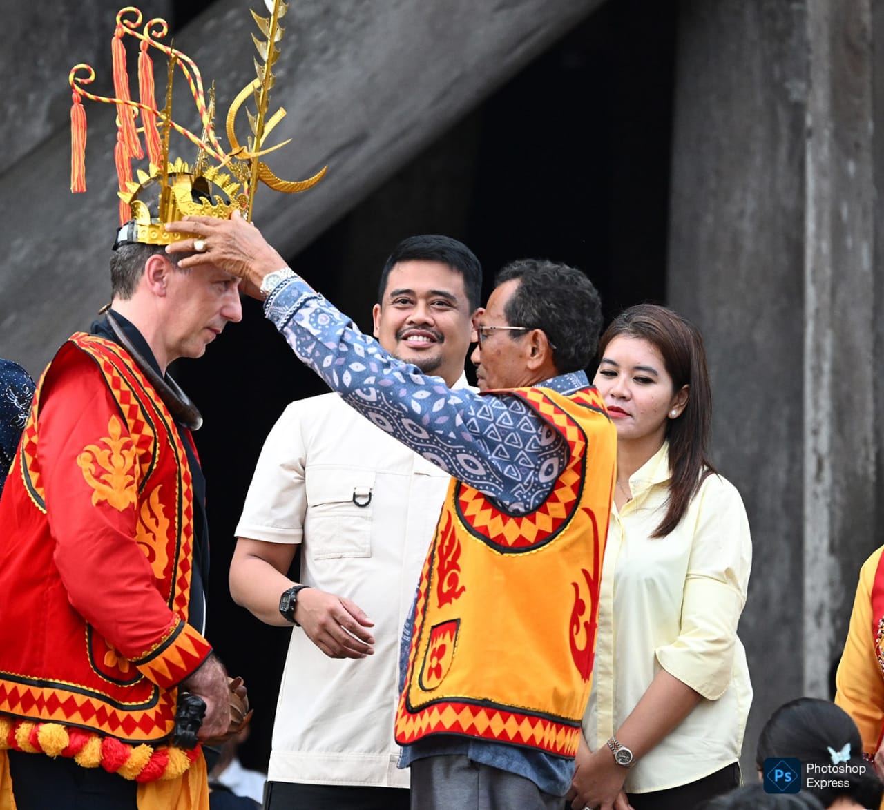 IMG-20260718-WA0014 Bobby Nasution didampingi Kahiyang Ayu menyaksikan ketua adat memakaikan topi adat ke Dubes Perancis. (Kominfo Sumut Dok)